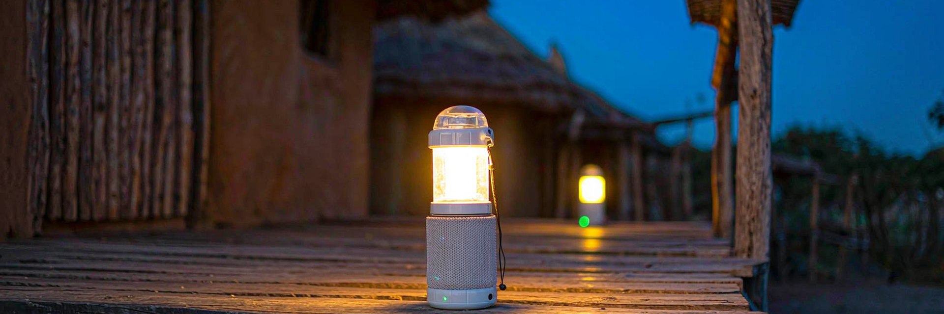 Rechargeable solar lantern glowing on a veranda table at dusk — AI-generated illustrative scene