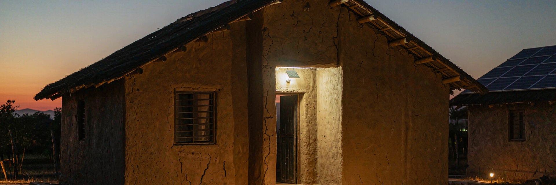 Home exterior at night lit by solar wall and garden lights — AI-generated illustrative scene
